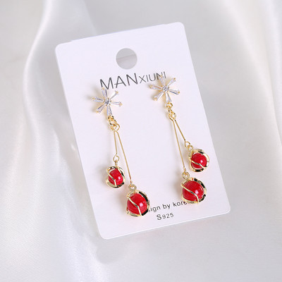 Női fülbevaló dekoratív piros és fehér gyöngyökkel