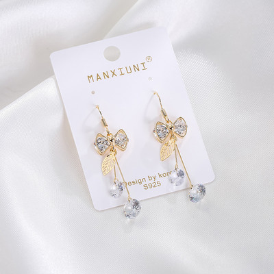 Női fülbevaló dekoratív szalaggal és kristályokkal